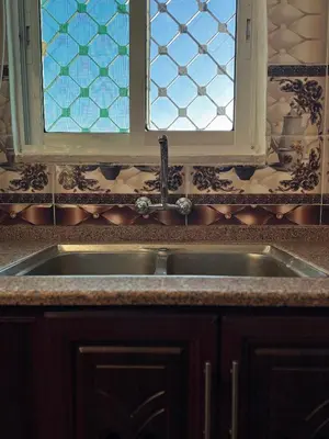 a kitchen with a sink and two windows at Salem Guesthouse Experience in Al Ḩayy