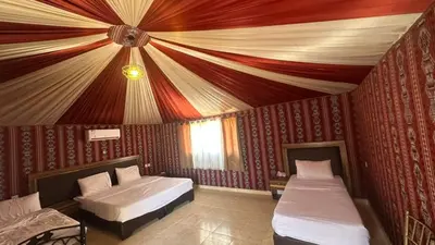 a bedroom with two beds and a ceiling at Wadi Rum Luxury Trend in Wadi Rum