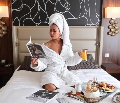a woman sitting on a bed reading a book at WADI RUM BUBBLES lUXURY CAMP in Disah