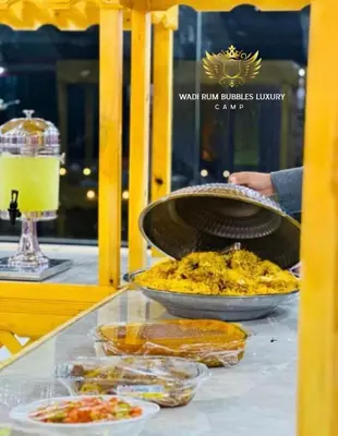 a glass table with food on top of it at WADI RUM BUBBLES lUXURY CAMP in Disah