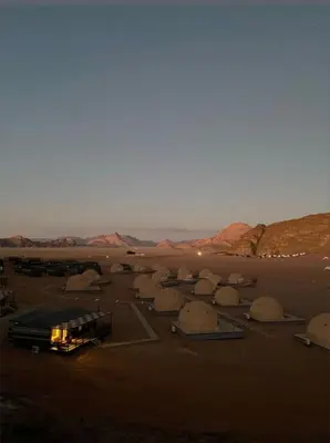 a bus parked in a parking lot in the desert at Wadi Rum Nada Camp in Wadi Rum