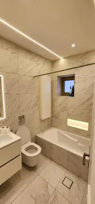 a bathroom with a tub and a toilet and a sink at Horizon 3 in Al Qarţū‘īyah