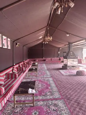 an empty room with red chairs and a rug at Wadi rum camp teem in Wadi Rum