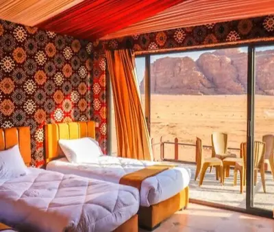 a bedroom with two beds and a view of the desert at ULORA Luxury Camp in Wadi Rum
