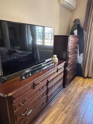 a dresser with a large tv on top of it at In Balm Society ضاحية النخيل BR 3 Super Deluxe in Amman