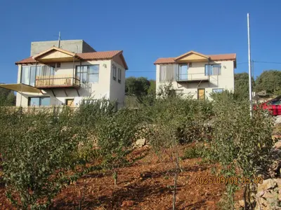 a house on top of a hill with bushes at اكواخ الملول عجلون 2 in Ajloun