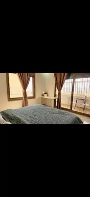 a bedroom with a bed and a window with curtains at Qqq in Amman