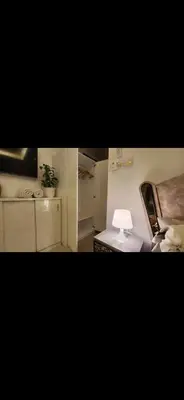 a room with a bed and a table with a lamp at Qqq2 in Amman