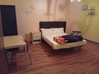 a bedroom with a bed with a table and a desk at Petra Neighbor Hostel in Wadi Musa