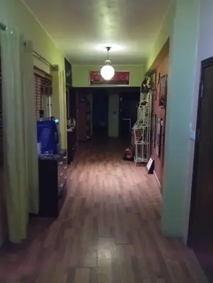 a hallway with a hard wood floor and a light fixture at Petra Neighbor Hostel in Wadi Musa