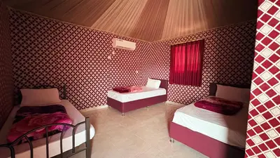 a room with two beds and a table in it at Hello Desert Camp & Tour