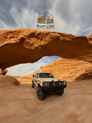 a truck parked under an arch in the desert at Rum Lian Luxury Camp & Bubble Hotel in Disah