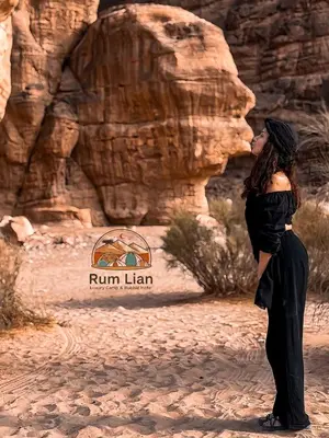a woman kissing in front of a rock wall at Rum Lian Luxury Camp & Bubble Hotel in Disah