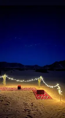 a lit up beach with a string of lights at Wadi Rum -Lekshary Hamza 55 in Wadi Rum