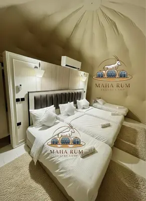 two beds in a hotel room with signs on them at MAHA Rum Luxury Camp in Disah