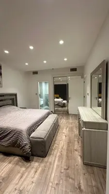 a bedroom with a large bed and a large mirror at Rashed's apartments at DAMAC Tower in Amman