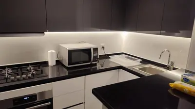 a kitchen with a microwave and a sink at Rashed's apartments at DAMAC Tower in Amman