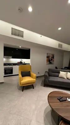 a living room with a couch and a yellow chair at Rashed's apartments at DAMAC Tower in Amman