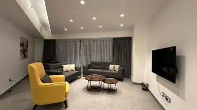 a living room with a couch and a tv at Rashed's apartments at DAMAC Tower in Amman