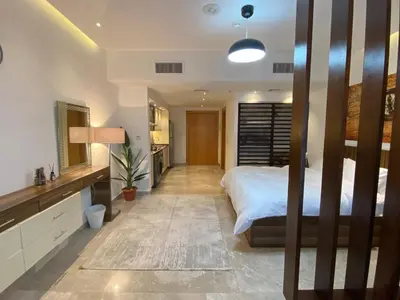 a bedroom with a large bed and a bathroom at luxury apartments at DAMAC tower amman للعائلات برج داماك in Amman