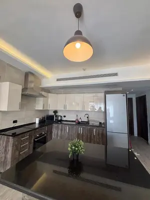 a kitchen with a refrigerator and a vase of flowers at شقة مميزة في عبدون هيلز-Modern Apartment in Abdoun Hills in Amman