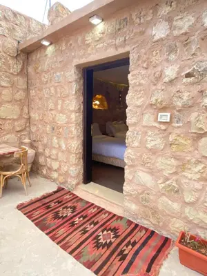 a bedroom with a bed in a stone wall at Petra Gateway Guest Room in Wadi Musa