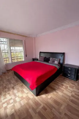 a bedroom with a large bed with a red blanket at Um Al Namel Villa & Chalet