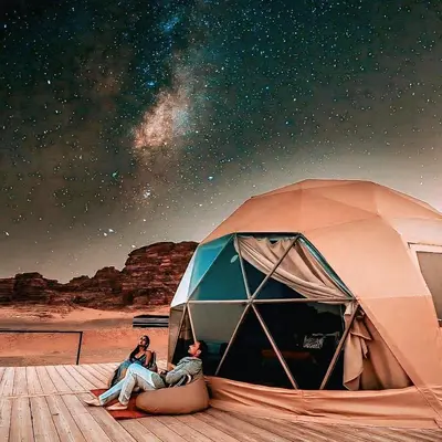 two people sitting in a tent under the stars at Wadi Rum Guide , Luxury Camp