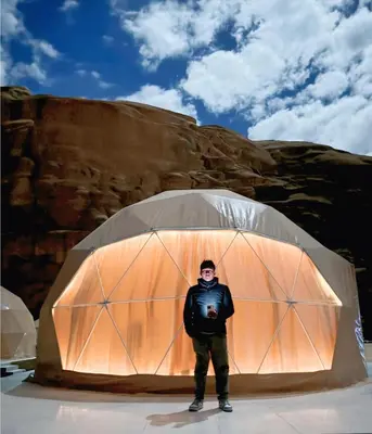 a man standing in front of a dome tent at Wadi Rum Guide , Luxury Camp