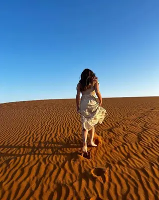 a woman standing in the sand in the desert at Isabella Desert Camp & Tour in Wadi Rum