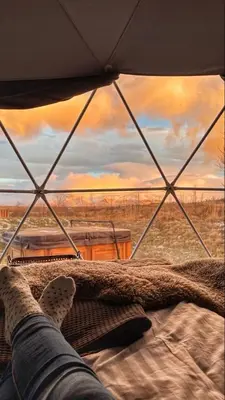 a person laying on a bed looking out of a tent at Rum nore in Disah
