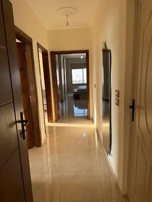 a hallway leading to a living room with a view of a house at شقة للإيجار في راس منيف - عجلون in Ajloun