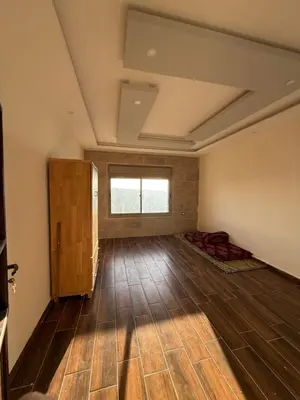 a large room with wooden floors and a window at شقة للإيجار في راس منيف - عجلون in Ajloun