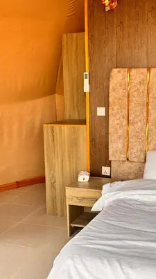 a bedroom with two beds and a wooden wall at Yazeed in Disah