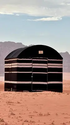 a black and white object sitting in the desert at Wadi Rum Mountains in Wadi Rum