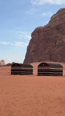 two train cars in the desert near a mountain at Wadi Rum Mountains in Wadi Rum