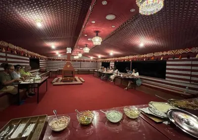 a room with people sitting at tables in a restaurant at Wadi Rum Mountains in Wadi Rum