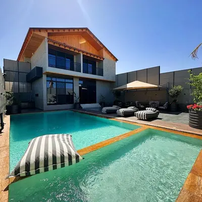 a swimming pool in front of a house at Haifa Villa by Seahorse in Sowayma