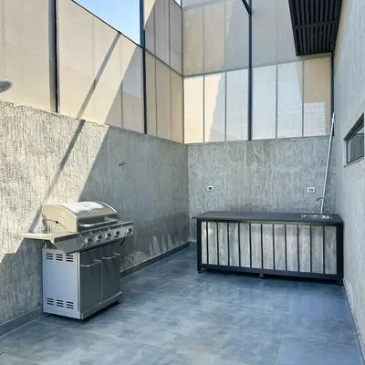 a kitchen with a grill and a table in a building at Haifa Villa by Seahorse in Sowayma