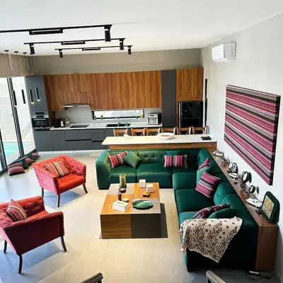 a living room with a green couch and red chairs at Haifa Villa by Seahorse in Sowayma