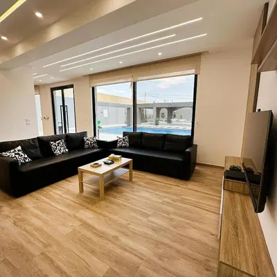 a living room with a black couch and a table at La Mer Villa by Seahorse in Al Rama
