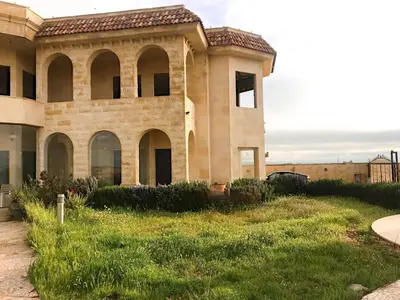 an old building with a grass yard in front of it at Appartment in Amman within a villa