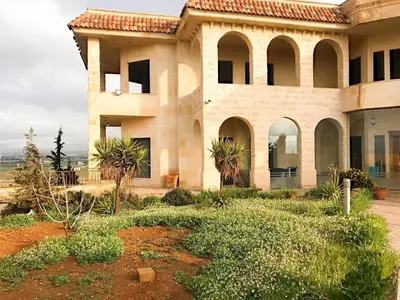 a large house with trees in front of it at Appartment in Amman within a villa