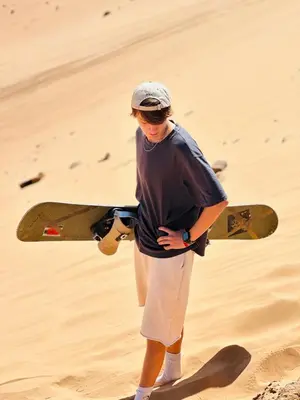 a man holding a skateboard in the desert at Wadi Rum Starfield Retreat in Wadi Rum