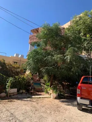 a red van parked in front of a building at Petra Neighbor Hostel in Petra