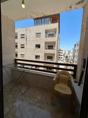a balcony with a chair and a window with a building at شقة مفروشة in Amman