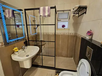 a bathroom with a shower and a sink and a toilet at شقة فاخرة في دير غبار in Amman