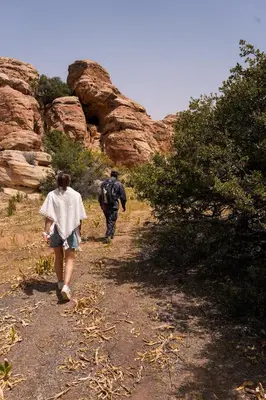 a couple of people walking down a dirt trail at Dana Trail Nomad Camp in Dana