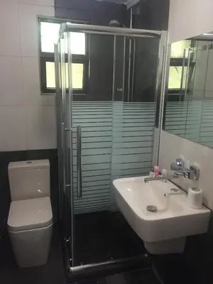 a bathroom with a toilet and a sink and a shower at Masaya Al Deyar Apartments in Amman