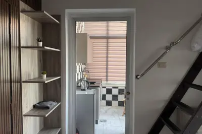 a hallway with a staircase leading to a room with a window at Modern Loft Studio Panoramic Views And Smart Design in Amman